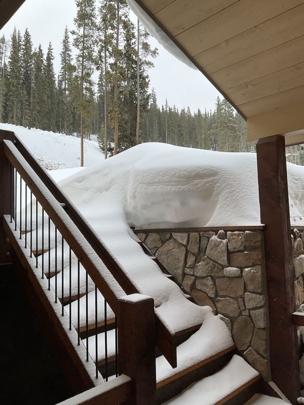 Deep snow drifts on the front stairs and stone wall