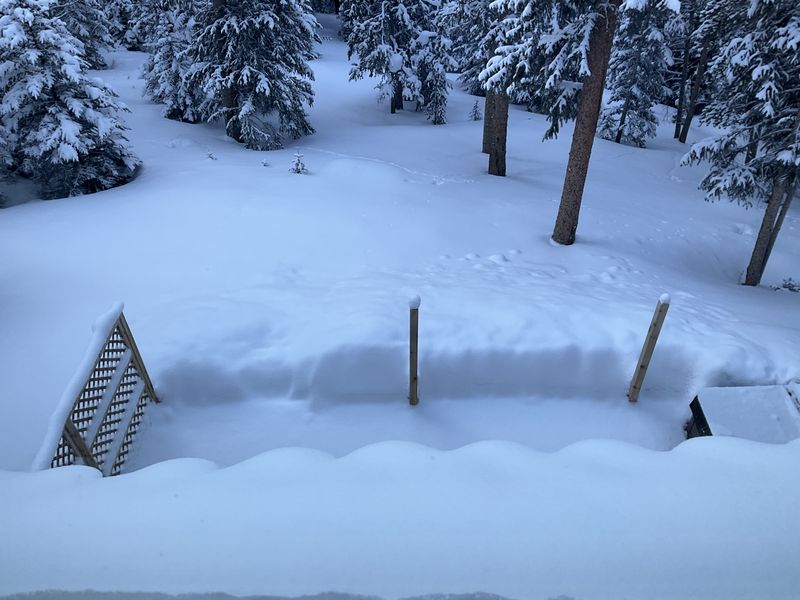 Backyard deck and fence buried in deep snow