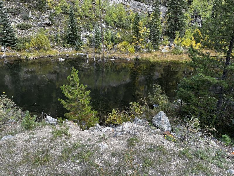 Still alpine lake reflecting autumn colors and rock face