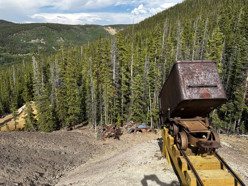 Historic mining ore cart on tracks at a mountain mine site