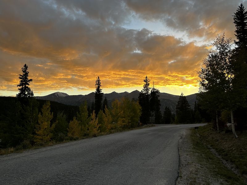 Fiery sunset over a mountain road with autumn foliage