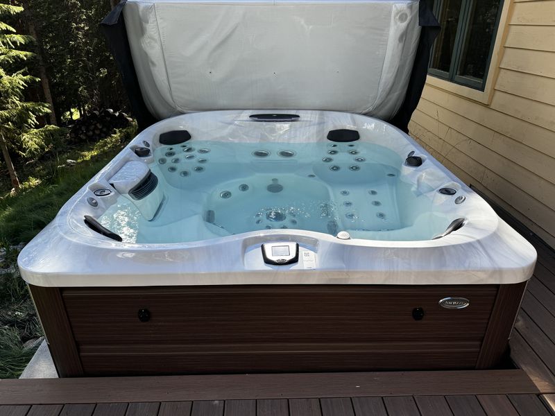 Hot tub open on the deck surrounded by trees